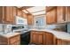 Galley kitchen with wood cabinetry, white appliances, and bright countertops at 711 Felspar Dr, Apache Junction, AZ 85119
