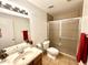 Bright bathroom with tiled shower, vanity, and ample lighting at 7754 W Mitchell Dr, Phoenix, AZ 85033