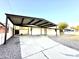 Driveway with carport, landscaping, and a modern privacy fence at 7754 W Mitchell Dr, Phoenix, AZ 85033