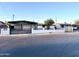 Charming single-story home featuring a covered carport and modern horizontal slat privacy fence at 7754 W Mitchell Dr, Phoenix, AZ 85033