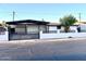 Charming single-story home featuring a covered carport and modern horizontal slat privacy fence at 7754 W Mitchell Dr, Phoenix, AZ 85033