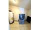 Utility room featuring tile flooring and a modern washer-dryer combination with adjacent water heater at 7754 W Mitchell Dr, Phoenix, AZ 85033