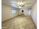 Open-concept living room featuring tile floors, ceiling fan and a small table at 7754 W Mitchell Dr, Phoenix, AZ 85033