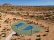 Aerial view of a basketball court with seating in a desert community surrounded by homes and mountain views at 8043 E Jaeger St, Mesa, AZ 85207