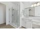 Elegant bathroom featuring double sinks, a glass-enclosed shower, and white cabinets at 8043 E Jaeger St, Mesa, AZ 85207