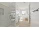 Bright bathroom featuring double sinks, a soaking tub, glass enclosed shower and light wood flooring at 8043 E Jaeger St, Mesa, AZ 85207