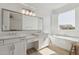 Bright bathroom featuring double sinks, a vanity, a soaking tub, and natural light at 8043 E Jaeger St, Mesa, AZ 85207