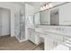 Elegant bathroom featuring double sinks, white cabinets, and a glass-enclosed shower at 8043 E Jaeger St, Mesa, AZ 85207