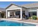 Spacious covered patio with a cozy fireplace, comfortable seating, and a grill, overlooking the pool at 8043 E Jaeger St, Mesa, AZ 85207