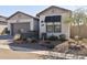 Single-story home showcasing desert landscaping, a two-car garage, and a window with a black awning at 8043 E Jaeger St, Mesa, AZ 85207