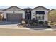 Charming single-story home featuring desert landscaping, a two-car garage, and a welcoming front entrance with black awning at 8043 E Jaeger St, Mesa, AZ 85207