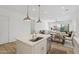 Kitchen island featuring a stainless steel sink, white cabinetry, and views of the open floor plan at 8043 E Jaeger St, Mesa, AZ 85207