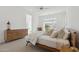 Cozy main bedroom featuring a large window with shutters, carpet, and neutral paint at 8043 E Jaeger St, Mesa, AZ 85207