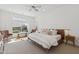 Stylish bedroom featuring carpet, a ceiling fan, a bench, and a large window with shutters at 8043 E Jaeger St, Mesa, AZ 85207