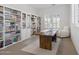 Spacious home office with built-in bookshelves, a large desk, and natural light at 8043 E Jaeger St, Mesa, AZ 85207