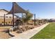 Community playground featuring a climbing structure, shade canopy, walking path, and manicured landscaping at 8043 E Jaeger St, Mesa, AZ 85207