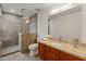 Modern bathroom with a glass-enclosed shower and wood vanity with granite countertop at 8340 E Rowel Rd, Scottsdale, AZ 85255