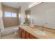 Bright bathroom featuring double sinks with granite countertop and a shower/tub combo with beige tile at 8340 E Rowel Rd, Scottsdale, AZ 85255
