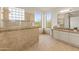 Bathroom featuring a large shower, tile, and dual windows at 8340 E Rowel Rd, Scottsdale, AZ 85255