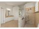 Bathroom featuring tile floors, walk-in tiled shower with seat, and vanity with double sinks and decorative lighting at 8340 E Rowel Rd, Scottsdale, AZ 85255