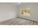 This bedroom features wood-look floors and a sunny window view at 8340 E Rowel Rd, Scottsdale, AZ 85255
