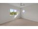 Empty bedroom features neutral carpet, large window, unique circular window, and ceiling fan at 8340 E Rowel Rd, Scottsdale, AZ 85255