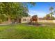 Lush backyard with a play structure and covered patio, perfect for outdoor entertaining at 8821 N 9Th Ave, Phoenix, AZ 85021