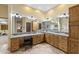 A well-lit Primary bathroom with wood cabinets, double vanity, a decorative mirror and tile flooring at 8821 N 9Th Ave, Phoenix, AZ 85021