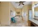 A bright bathroom featuring a large jacuzzi tub, floral accent chair, and vanity with a beige tile floor at 8821 N 9Th Ave, Phoenix, AZ 85021