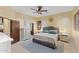 A stylish primary bedroom featuring neutral walls, decorative ceiling fan, and a tufted headboard bed with a grey rug at 8821 N 9Th Ave, Phoenix, AZ 85021