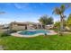 Serene backyard with a sparkling pool, lush green lawn, and mature landscaping at 8821 N 9Th Ave, Phoenix, AZ 85021