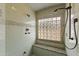 A spacious shower with green tile walls, a glass block window and shower head with a built-in bench at 8821 N 9Th Ave, Phoenix, AZ 85021