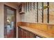 An elegant wine cellar with custom wine racks, beautiful stone backsplash, and rustic wood cabinetry at 8821 N 9Th Ave, Phoenix, AZ 85021