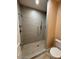 Modern walk-in shower with sleek tile walls, dual showerheads, and mosaic tile flooring at 9408 W Jackson St, Tolleson, AZ 85353