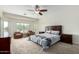 Bedroom with neutral carpet, ceiling fan, stylish furnishings, and view at 9768 W Prospector Dr, Queen Creek, AZ 85144