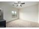 Bright, carpeted bedroom features a ceiling fan and a window providing natural light at 9768 W Prospector Dr, Queen Creek, AZ 85144