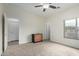Cozy carpeted bedroom includes a ceiling fan, closet, and dresser at 9768 W Prospector Dr, Queen Creek, AZ 85144