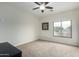 Inviting bedroom with plush carpet, a ceiling fan, and a large window at 9768 W Prospector Dr, Queen Creek, AZ 85144