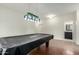 Spacious game room features tile floors, modern lighting, and access to the bathroom at 9768 W Prospector Dr, Queen Creek, AZ 85144
