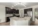 Well-equipped kitchen with dark cabinets, granite countertops, and a central island at 9768 W Prospector Dr, Queen Creek, AZ 85144