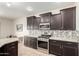 Spacious kitchen with dark cabinets, stainless steel appliances, and a mosaic tile backsplash at 9768 W Prospector Dr, Queen Creek, AZ 85144