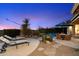 Spacious backyard with lounge chairs, patio table, desert plants, and serene sunset views at 11617 E Raintree Dr, Scottsdale, AZ 85255