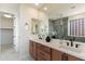 Well-lit primary bathroom with double sinks, quartz countertop, modern fixtures, and a tiled glass shower at 11617 E Raintree Dr, Scottsdale, AZ 85255