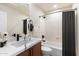 Bright bathroom featuring a white marble vanity, modern fixtures, and a shower-tub with a gray curtain at 11617 E Raintree Dr, Scottsdale, AZ 85255