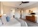 Bright bedroom boasts a ceiling fan, en-suite bathroom, and stylish wooden dresser at 11617 E Raintree Dr, Scottsdale, AZ 85255
