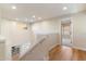 Bright hallway with hardwood floors leading to a bedroom and overlooking the home's main level at 11617 E Raintree Dr, Scottsdale, AZ 85255