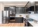 Well-equipped kitchen showcasing modern, dark cabinets, stainless steel appliances, and ample counter space for culinary endeavors at 11617 E Raintree Dr, Scottsdale, AZ 85255