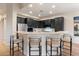 Kitchen island with black cabinets, quartz countertop, and comfortable bar seating at 11617 E Raintree Dr, Scottsdale, AZ 85255
