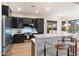 Spacious kitchen with an island, black cabinets, and stainless steel appliances at 11617 E Raintree Dr, Scottsdale, AZ 85255