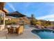 Inviting pool area featuring a table with umbrella and beautiful desert mountain views at 11617 E Raintree Dr, Scottsdale, AZ 85255